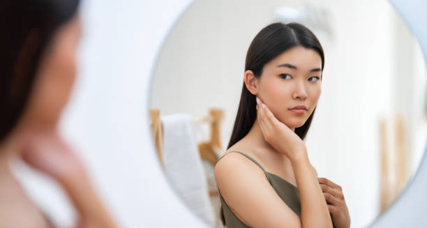 istock woman looking at mirror 1458741671