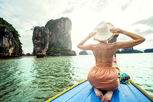 Real photo of traveler woman on the long tail boat looking at the James Bond island Phuket, Thailand, Asia. Tourism destination.