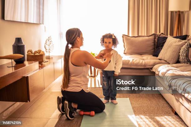 Mother Helping Daughter Getting Dressed At Home Stock Photo - Download Image Now - A Helping Hand, Assistance, Dress
