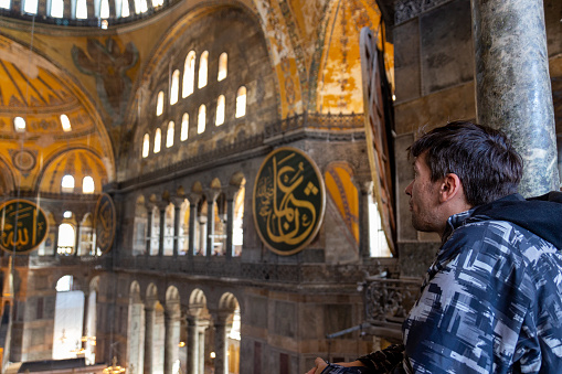 Istanbul, Turkey - October 9, 2019: European male traveler looking the interiors of the Hagia Sophia