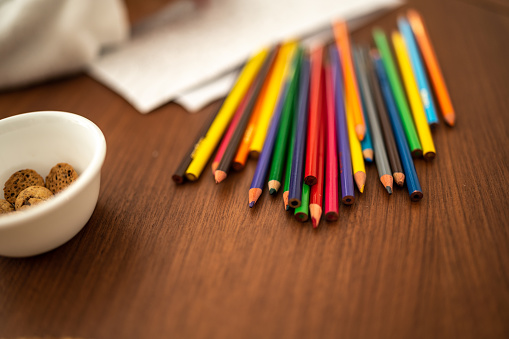 Close-up of table with colored pencils and cookie bowl