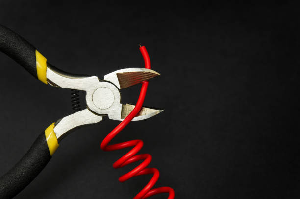 istock Wire cutters and red wire closeup on black background. Electronics Repair Idea 1458742839