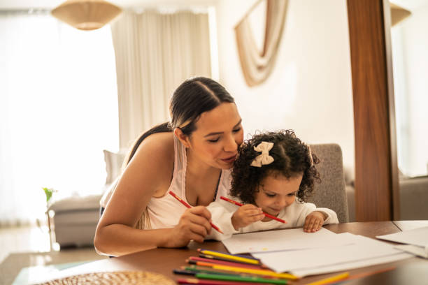 istock Mother helping her daughter to draw at home 1458742936