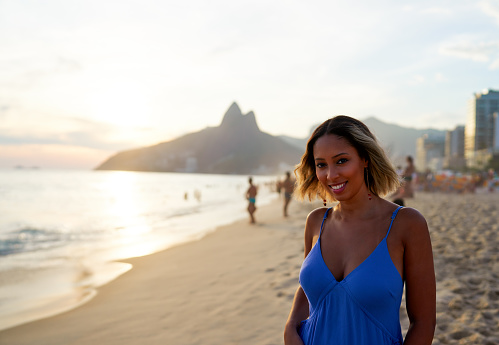 portrait young smiling Brazilian woman at Ipanema beach shore at sunset