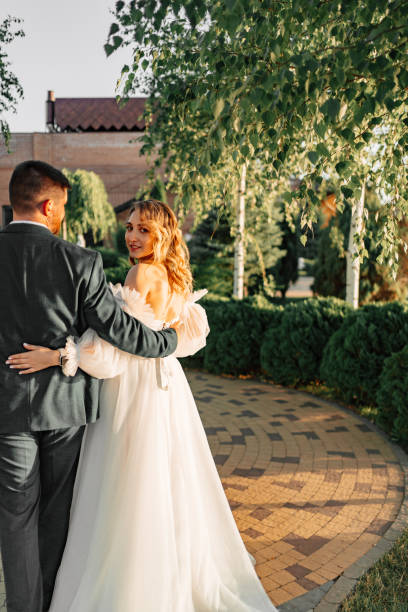 istock view from the back. the bride and groom walk hugging along the path 1458748298