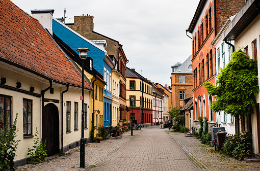 Historical alley with typical Swedish houses in Malmo Gamla Stan or Malmö old town. Swedish cobbled alleyway rich with plants and bicycles parked on its sides shows the Nordic ancient architecture