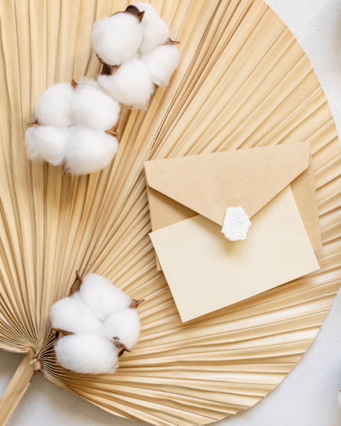 istock Blank card and envelope on dried palm leaf with cotton flowers top view, wedding mockup 1458751490
