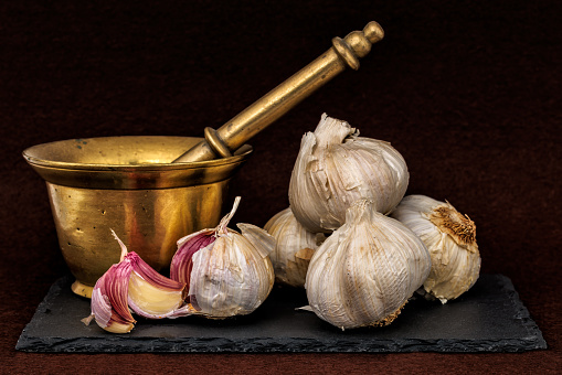 Garlic cloves on rustic table. Garlic in bowl. Fresh peeled garlic and bulbs.