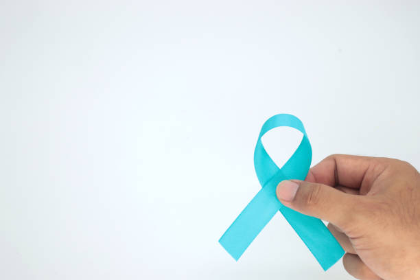 istock hand holding light blue ribbon on white background,November Pros 1458777169
