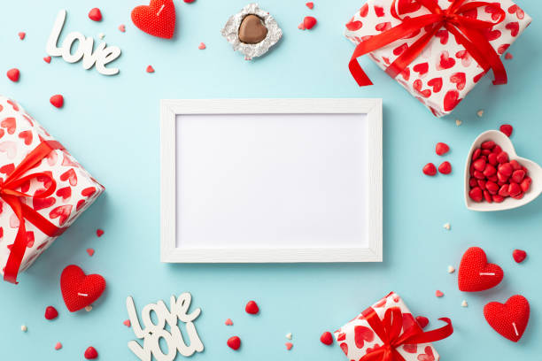 valentine's day concept. top view photo of photo frame present boxes heart shaped candles candies inscriptions love and saucer with sprinkles on isolated pastel blue background with copyspace - valentines day candy chocolate candy heart shape imagens e fotografias de stock