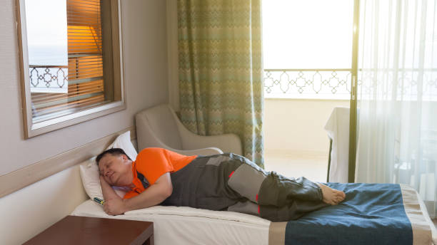 Lazy worker man lay down to sleep on the bed during working hours Lazy worker man lay down to sleep bed during working hours. lazy construction laborer stock pictures, royalty-free photos & images