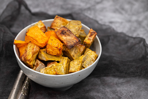 Homemade Cooked Sweet Potato with spices and herbs in smal gray bowl