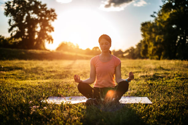 istock Young Woman Meditating In The Park 1458781412