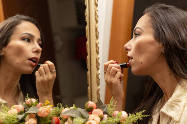 istock A woman putting on lipstick. 1458782135