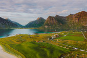 Aerial view of the fisherman village by the ocean and the mountains during scenic sunset on Lofoten Islands
