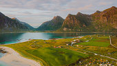 Aerial view of the fisherman village by the ocean and the mountains during scenic sunset on Lofoten Islands