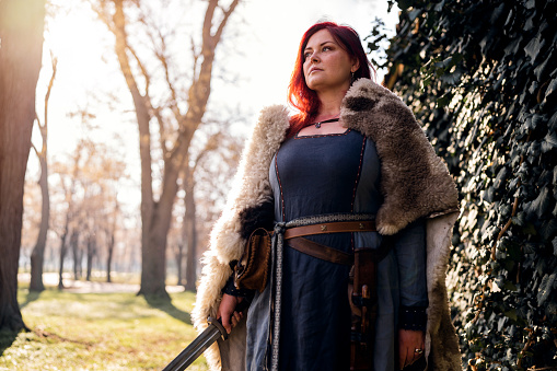 Portrait of mid-adult medieval female warrior in the forest