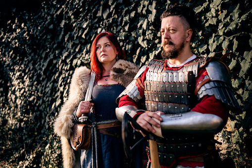 Medieval couple, in medieval costume, in front of the fort