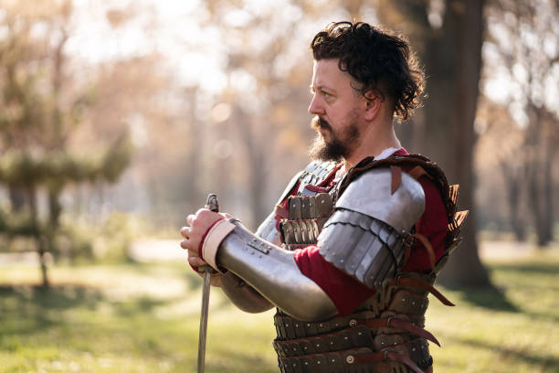 istock Male medieval warrior kneeling while holding sword 1458783552