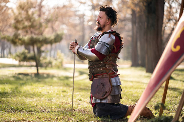 istock Male medieval warrior kneeling while holding sword 1458783600