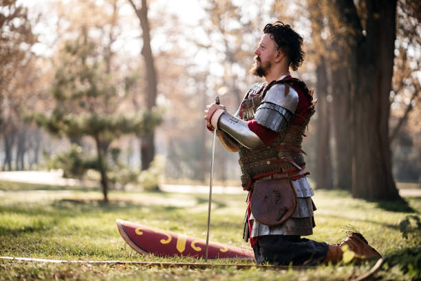 istock Male medieval warrior kneeling while holding sword 1458783671