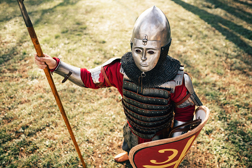 High angle view of unrecognizable medieval warrior wearing a steel helmet armed with a spear and shield