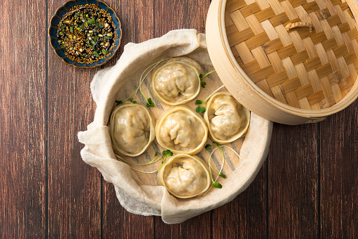 Delicious homemade Korean kimchi dumplings in a bamboo steamer viewed from above.