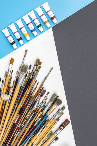 istock Brushes for drawing and paint on paper colored background, flat lay. 1458788315