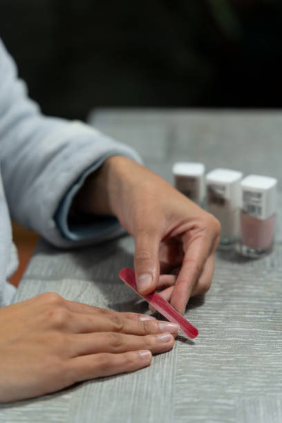 istock Hands of young girl doing her nails 1458792130