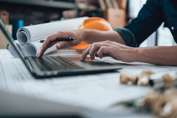 istock Engineering working with drawings inspection on laptop  in the office and Calculator, triangle ruler, safety glasses, compass, vernier caliper on Blueprint. Engineer, Architect, Industry and factory concept. 1458792366