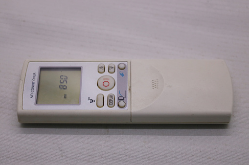 Air condirioner remote with white color that shown time at its display