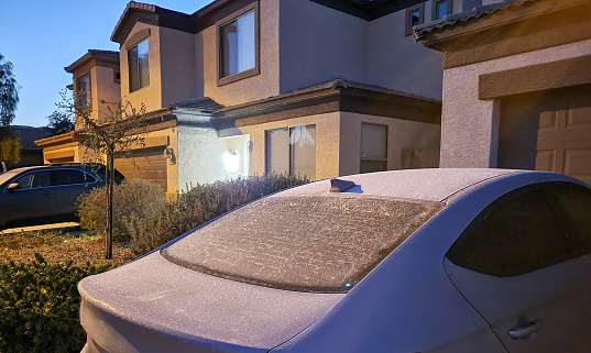 Car rear window and trunk covered with morning frost in Phoenix residential community, winter in Arizona