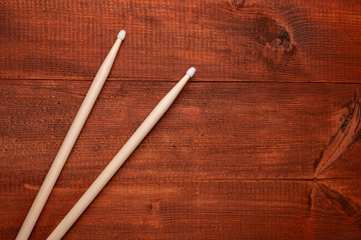 Two drumsticks on the dark wooden table