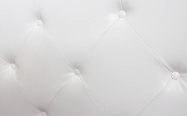 Beautiful white leather upholstery sofa with buttons. Skin texture, decorating