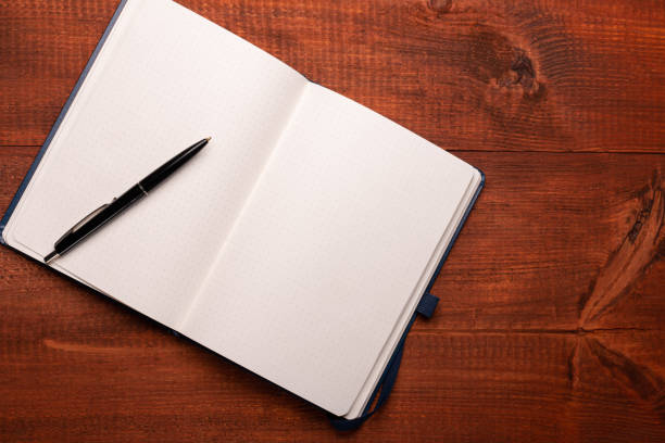 istock Open notebook with a pen on a wooden table 1458799371