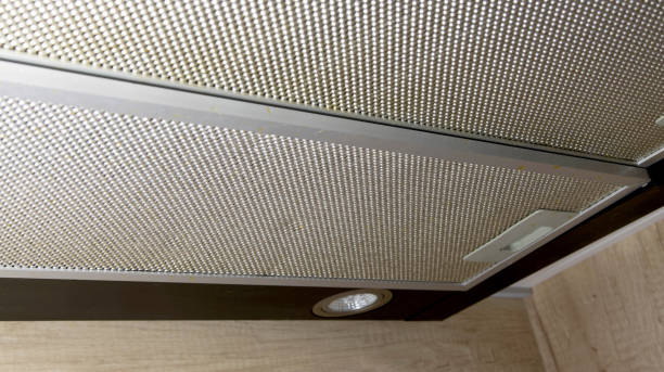 istock Modern kitchen hood with grease filter for air purification. Replacing the grease filter and maintaining the kitchen hood. 1458799942