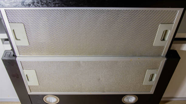 istock Modern kitchen hood with grease filter for air purification. Replacing the grease filter and maintaining the kitchen hood. 1458800011