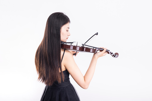 Selective blur. A girl's hand is holding the bow with which she is rubbing the strings of the violin.