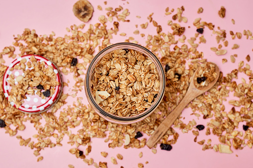 a jar of granola next to a wooden spoon