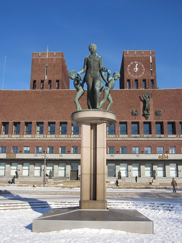 City Hall - Radhuset - in Oslo, Norway in wintertime. A Gustav Vigeland sculpture in front of the historic building.
