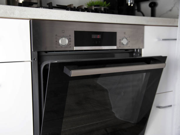 istock Black modern electric oven built into a white kitchen. Multifunction oven with grill 1458802597