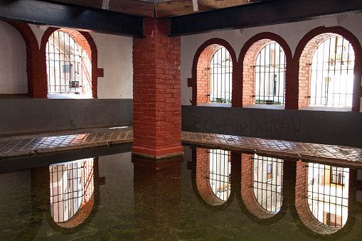 Ventanas reflejadas en uno de los antiguos lavaderos en Sant Mateu, Castellón