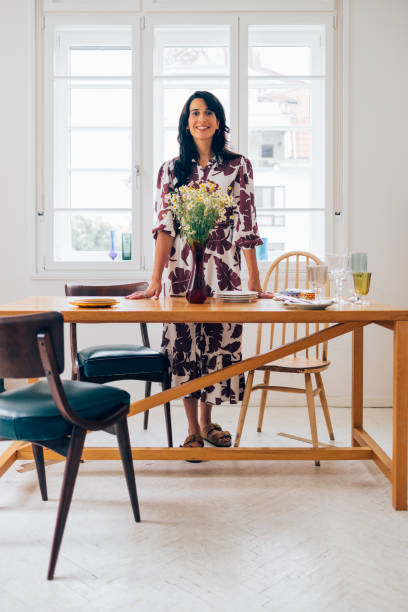 istock A Happy Beautiful Woman Looking At Camera While Preparing The Table For Lunch 1458805093