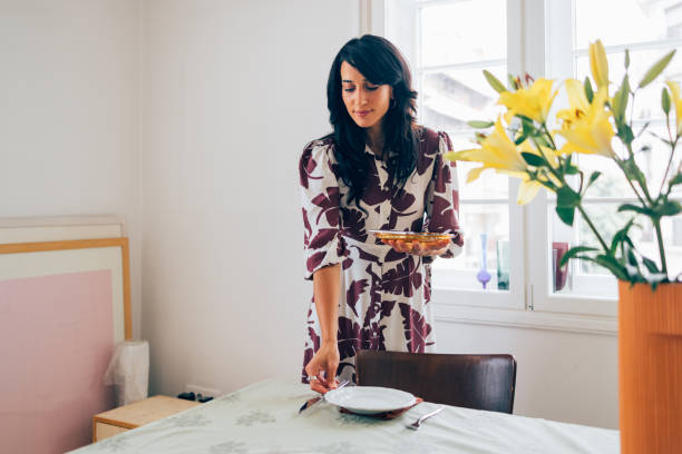 istock A Happy Beautiful Woman Preparing The Table For Lunch 1458805136