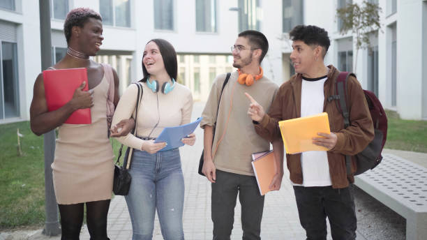 istock Four students standing, laughing on the university campus. Multi-ethnic group of students 1458805156