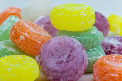 High angle view close-up of an assortment of colorful jellybeans, lollipops, candies and marshmallows.