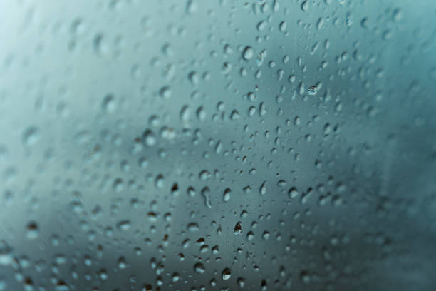 istock Rain water drops on the window in rainy season background 1458805595