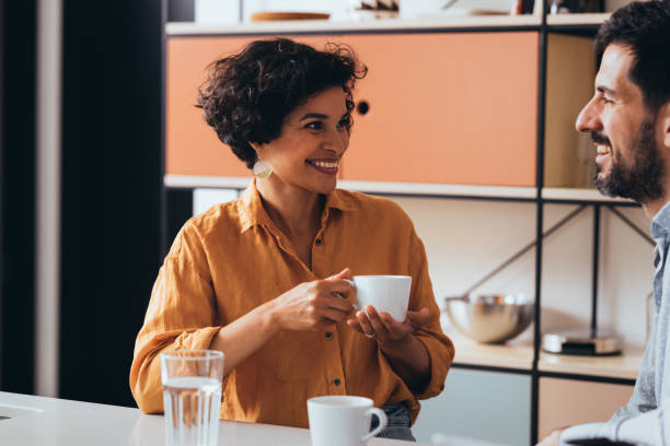 istock A Happy Beautiful Couple Sitting In The Kitchen And Talking 1458806911