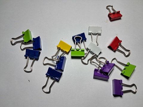 Colorful paperclip spreading all over the white place