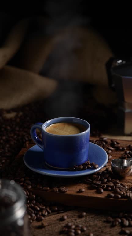 Coffee cup with smoke and coffee beans on old wooden background